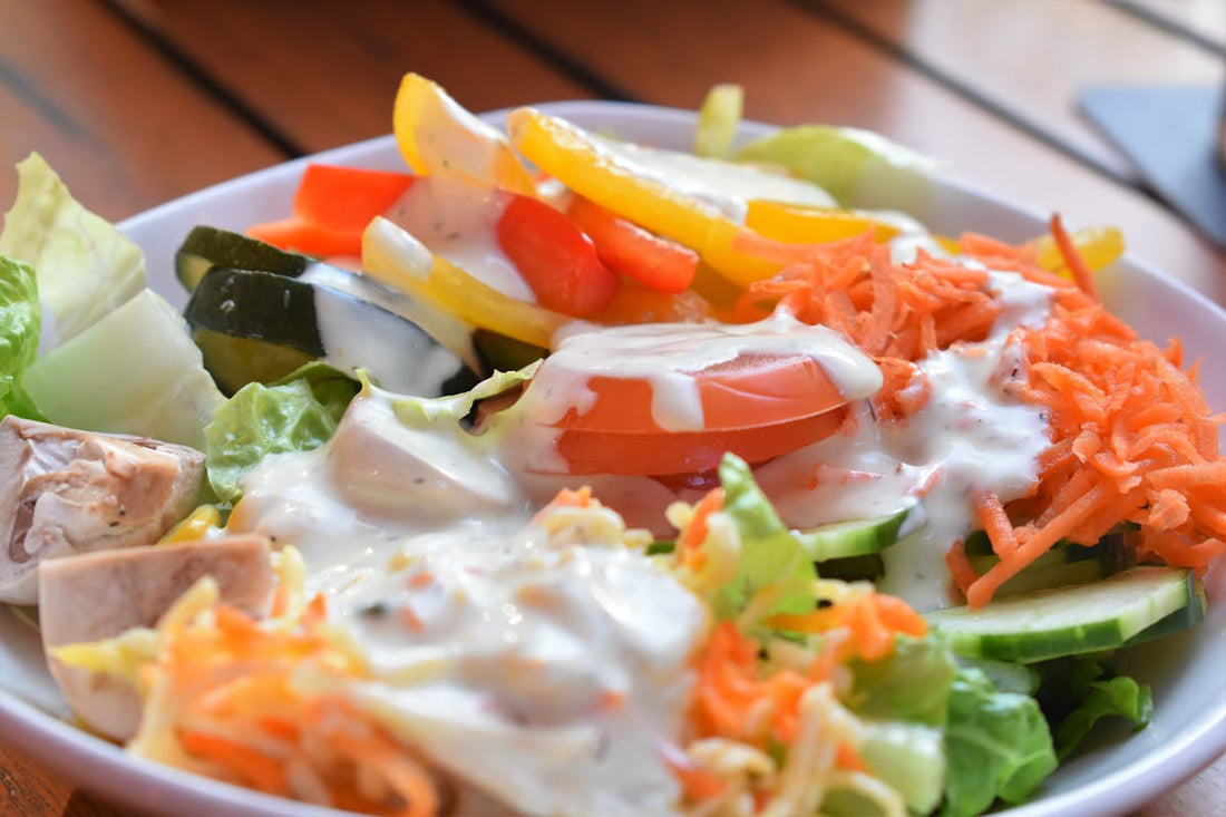 Creamy protein ranch dressing drizzled over fresh vegetables in a bowl