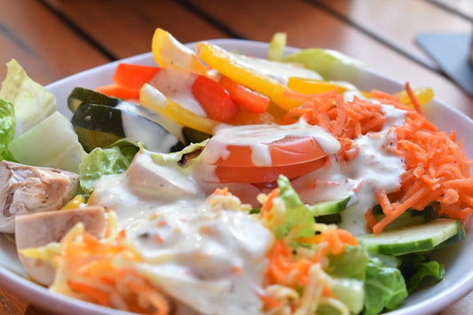 Creamy protein ranch dressing drizzled over fresh vegetables in a bowl